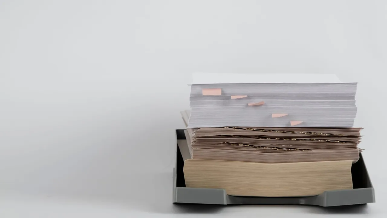 Pilhas de papéis e documentos empilhados em um arquivo.
